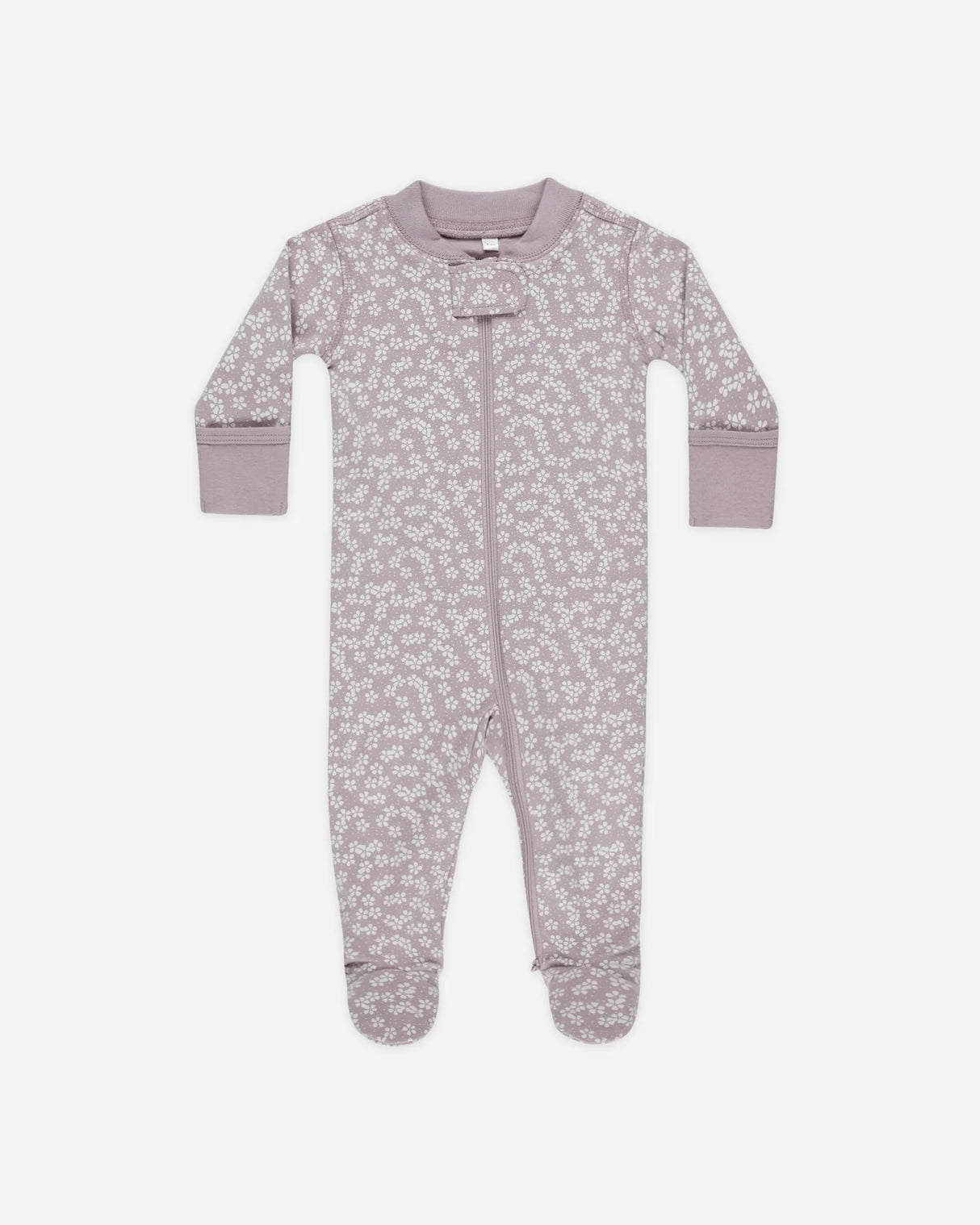 Soft 100% organic cotton baby footie with full-body zipper and lavender ditsy floral print. Includes fold-over mittens (sizes NB-6M) and anti-slip rubber soles (6-18M). Machine-washable for easy diaper changes.