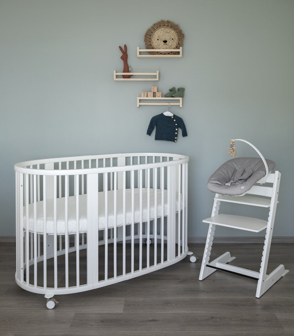 Stokke Sleepi Bed V3 – modern oval-shaped adjustable crib for babies and toddlers, with wheels and breathable slatted design.